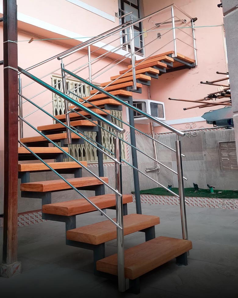 Escada em L, com corrimão em aço inox e degraus em madeira